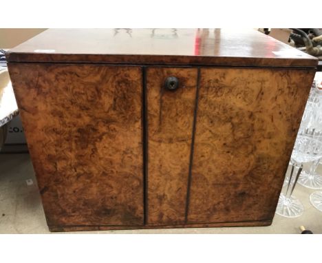 A late Victorian burr walnut humidor/cabinet, the offset doors opening to reveal three drawers, the door with a Bramah lock (