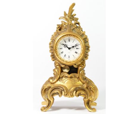 An early 20th century French mantel clock, gilt metal rococo style body, enamelled dial with Roman numerals, the hinged rear 