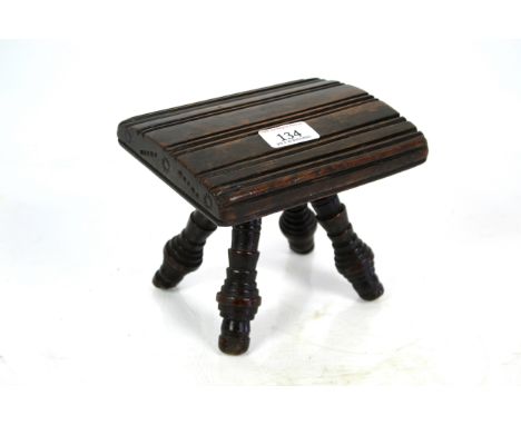 An unusual 18th Century Folk Art fruit wood foot stool with profusely bobbin turned legs and impressed sunburst design to eac