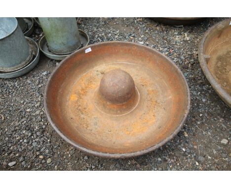 A circular cast iron pig trough 
