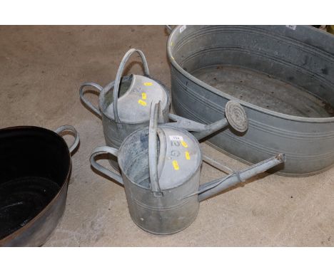 A vintage galvanised 2 gallon watering can and another with rose 
