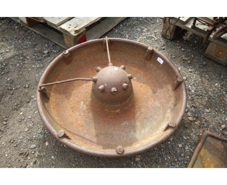 A circular cast iron pig trough 