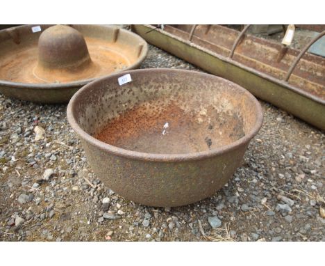 A circular cast iron trough