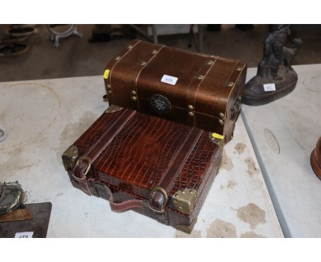 A small faux crocodile skin and metal a metal mounted suitcase and another metal bound miniature trunk