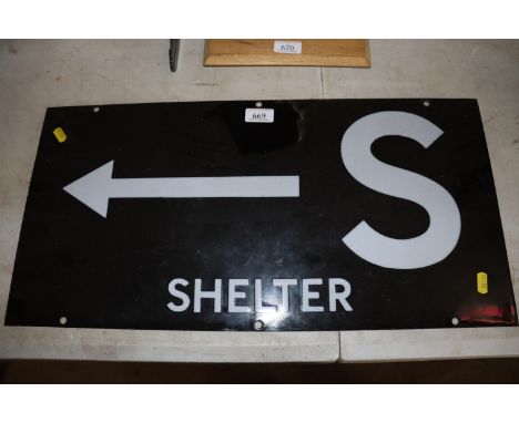 A black and white enamel Air Raid sign, marked  "Shelter" with an arrow pointing the way, approx. 12" x 24"