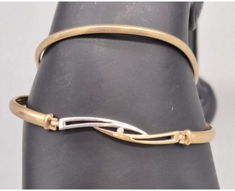 Two 9ct yellow gold bangles; One bangle fitted with a round cut diamond and partial white gold. 9Grams. 
