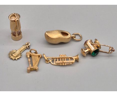 A Lot of Five 9ct &amp; one 14ct yellow gold charms; 14ct yellow gold clog charm, three musical instruments, minors lamp and 