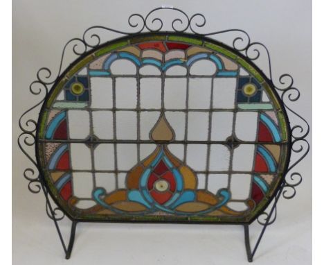 A good quality 20th Century firescreen With a scrolled metal edge, having stained glass panel, height 95cm, width 107cm.