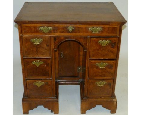 An early 18th Century flat topped kneehole deskOf small proportions, having burr walnut veneered drawer fronts, with long sin