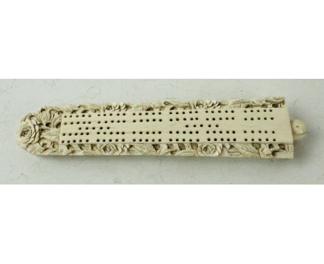 A late 19th/early 20th Century ivory cribbage boardHaving a board of carved floral decoration, complete with pieces to interi