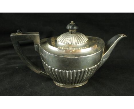 An Edwardian silver teapotOf oval form, with an embossed fluted lower body, the fluted domed lid with a turned ebonised finia