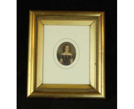 A 19th Century watercolour portrait miniatureDepicting a Victorian girl wearing a black and grey dress, 7x5.5cm, inset within