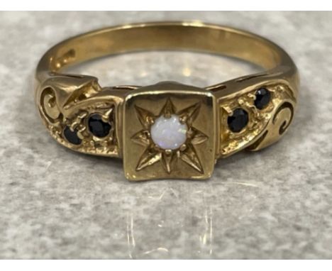 Ladies 9ct gold Sapphire and Opal ring. Comprising of a opal set in centre with 2 black sapphires set on each shoulder 3.1g s