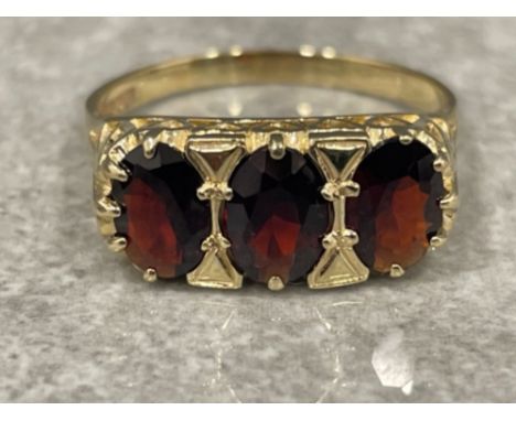 Ladies 9ct gold 3 stone Garnet ring. Comprising of 3 oval shaped stones and heart design shoulders. 3.3G size T