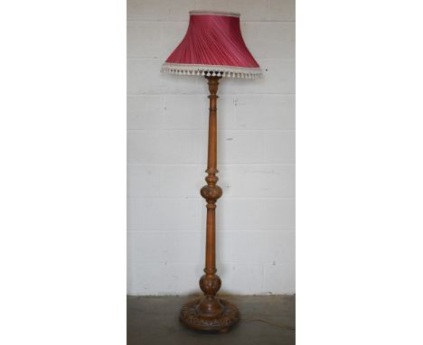 A turned carved and fluted hardwood standard lamp with pleated silk shade 