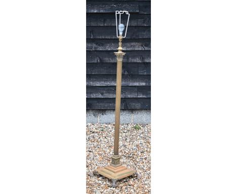 An adjustable brass classical column standard lamp on stepped square platform base with paw feet 