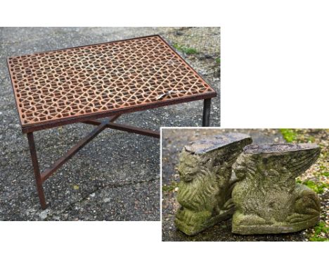 A weathered cast iron 'grate' coffee table within a steel frame raised on cross stretchers to/w a pair of cast reconstituted 