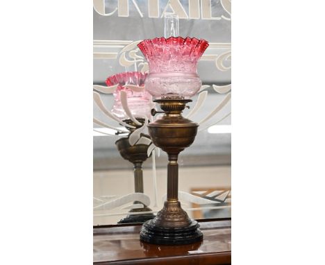 A Victorian brass oil lamp on reeded column, with etched cranberry shade, 65 cm overall 