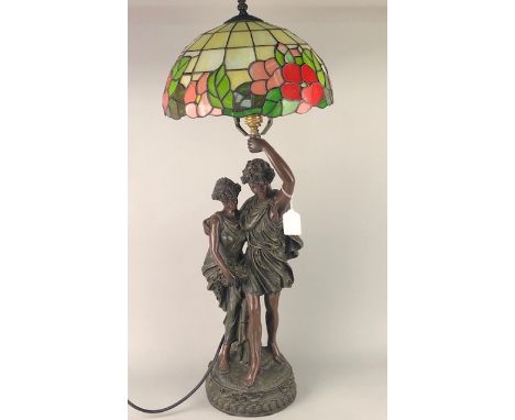 NEOCLASSICAL STYLE BRONZED FIGURAL LAMP, modelled with two figures, one holding aloft a stained glass shade