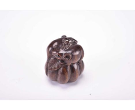 A Japanese carved wood netsuke of rats on a gourd, Meiji era Modelled as two rodents sitting on top of a pumpkin, their tails