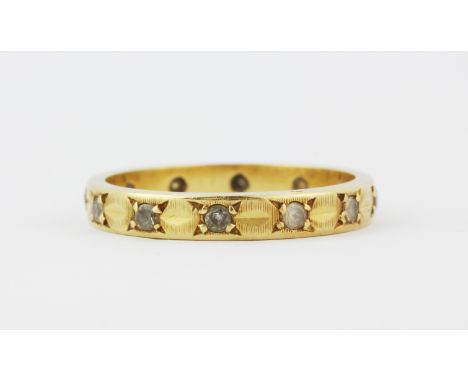 An 18ct yellow gold eternity ring set with white stones, (K.5).