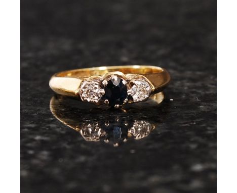 An 18ct gold diamond and sapphire ring. The central oval cut sapphire flanked by two diamonds approx 2.5pts each. Hallmarked 