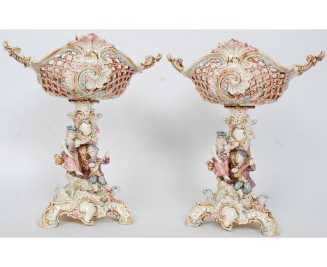 A pair of continental porcelain Italian centrepieces. The trefoil bases with applied boy and girl playing music having ribbon