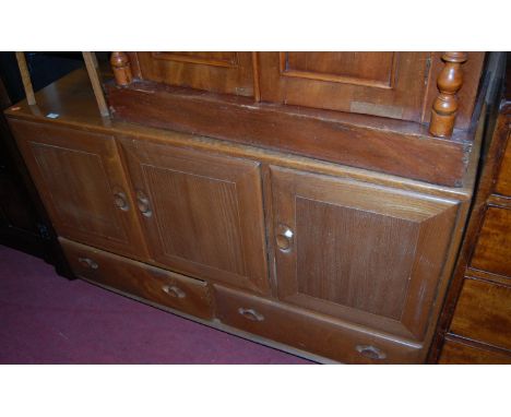 An Ercol blond elm three door sideboard, having twin lower drawers on castors, width 129cm