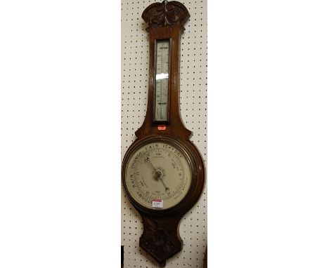 An early 20th century low relief carved oak aneroid two-dial wheel barometer 