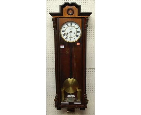 An early 20th century walnut droptrunk wall clock, having glazed trunk door, with twin weights, pendulum and winding key 