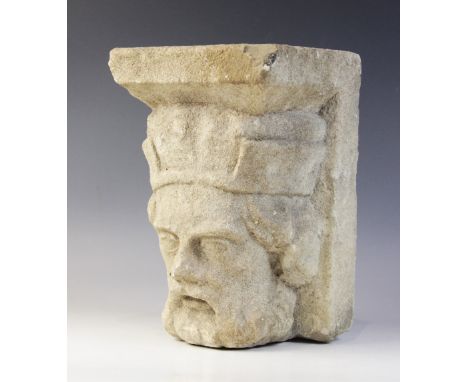 A carved stone corbel, in the medieval style, depicting the head of a bearded gentleman wearing a crown, 27cm high (at fault)