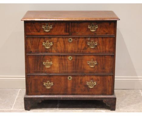 An early 18th century figured walnut chest of drawers, the rectangular top above two short and three graduated pine lined lon