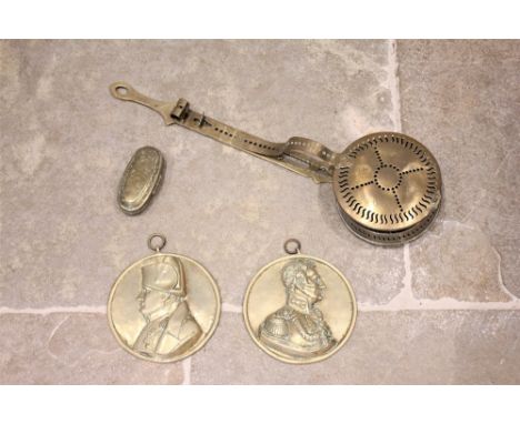 An 18th century Dutch brass tobacco box, of oval form, applied with chased decoration, 12cm long, a 19th century brass hangin