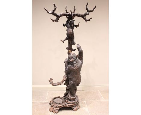 A 19th century Black Forest figural oak hall stand, naturalistically carved as a cub bear hanging from a tree trunk with moth