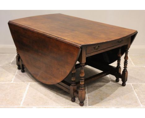 * An 18th century style oak drop leaf table, late 20th century, the oval top above a pair of opposing frieze drawers, raised 