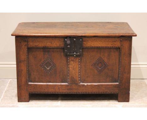 An 18th century oak coffer of cottage proportions, the rectangular moulded top above twin panels each centred with a carved l