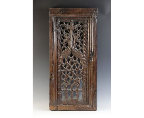 An early 16th century carved oak and pierced tracery panel, circa 1500, the rectangular panel flanked by spiral carved pilast