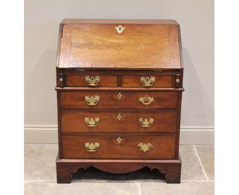 A George II and later mahogany bureau, the fall front opening to a compartmentalised interior, over two small frieze drawers 
