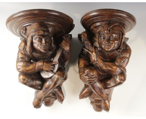 A pair of walnut beam ends, in the 16th century manner, one modelled as a jester the other a musician 33.5cm high x 23cm wide