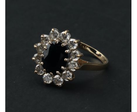 A 9 ct Gold Sapphire and Cubic Zirconia Cluster Ring,with oval cut dark blue sapphire with 12 ten-point size CZ stones, P 1/2