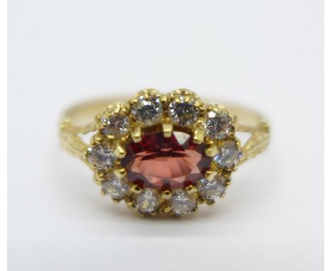 A 9ct gold cluster ring set with a garnet and cubic zirconia, 1.7g, M