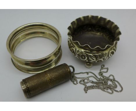 A silver salt, a silver napkin ring and a white metal pill holder on chain