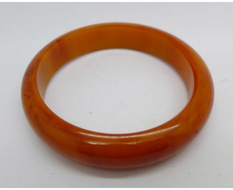 An amber coloured Bakelite bangle