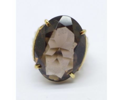 A yellow metal ring set with a large faceted smoky quartz, 6.9g, M