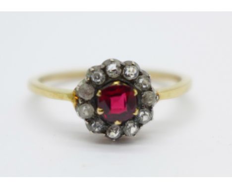 A Victorian cluster ring with silver settings, set with red and white stones, tests as gold, R