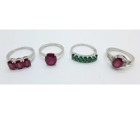 Four silver rings including ruby and emerald set