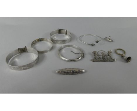 A Collection of Three Silver Child's Bangles, a Rams Head Silver Child's Bangle, a Silver Charm, a Silver Baby Brooch, Togeth