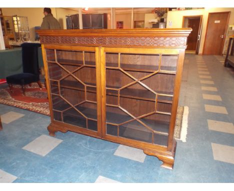 An Edwardian Mahogany Astragal Glazed Bookcase with Blind Carved Top Rail on Ogee Bracket Feet. 137cm Long