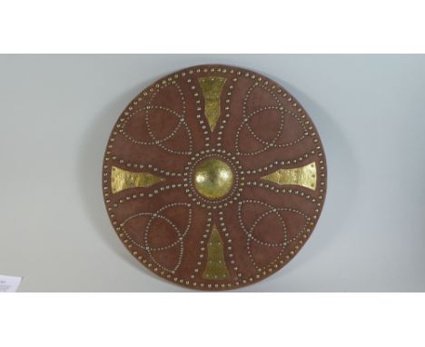 A Reproduction Celtic Shield of Red Leather Mounted with Pattered Brass Studwork, Forearm and Wrist Grips Verso.