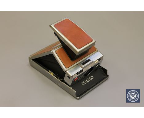 A vintage Polaroid SX-70 Land Camera CONDITION REPORT: This contains a battery but as far as I can gather it does not appear 